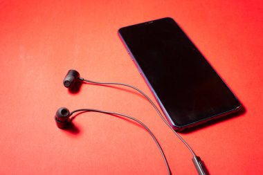 Siyah kulaklıklı, renkli bir cep telefonu. Hayatımızdaki teknoloji. Metin için boşluk