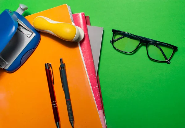 Yeşil Arka Planda Defterler Kitaplar Kalemler Gözlüklerle Dolu Bir Masanın Stok Fotoğraf