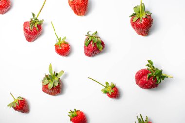 Beyaz arka planda yaprakları olan çilekler. Taze kırmızı olgun meyveler yenmeyi bekliyor..
