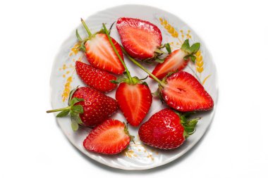 Beyaz arka planda yaprakları olan çilekler. Taze kırmızı olgun meyveler yenmeyi bekliyor..