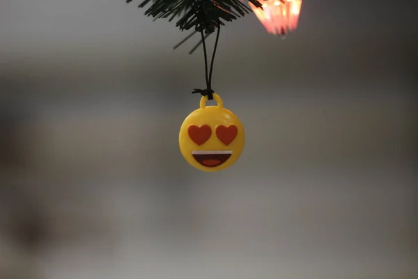 smiley toy hanging on a christmas tree