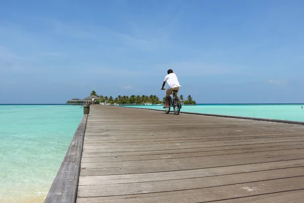 Man rides a bicycle on  wooden bridge in the direction of an Mal — Stock Photo, Image