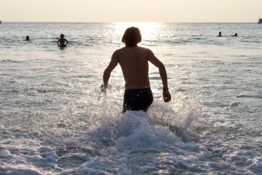 Deniz çalışan ve su sıçramasına adam siluet. Kıyısında tatil