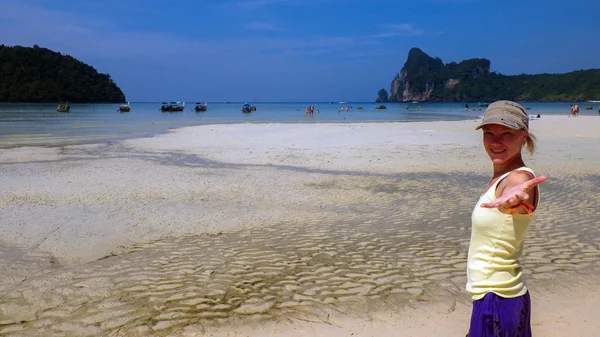 Bella ragazza agitando a mano mentre in piedi nel mare e guardando — Foto Stock