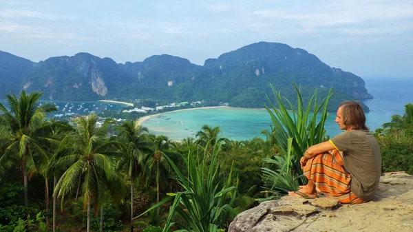 bir rock açık havada Phiphi Don Island, Tayland tarihinde oturan genç adam