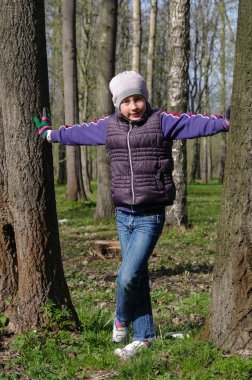 genç genç kız bir parkta iki gövde arasında ayakta