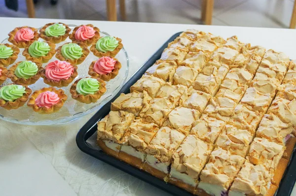 Torta di formaggio su un piatto e muffin, cupcake decorati — Foto Stock