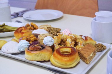 Bir kare plaka üzerinde taze pişmiş ev yapımı farklı baklava hamur işleri, kek ve sweetys