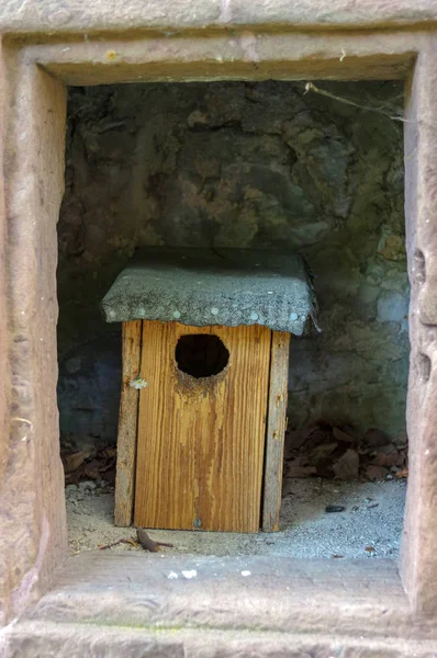 Mönstrad trä birdhouses stå i en stengrotta — Stockfoto