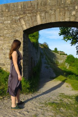 kadın elbise ayakta arka plan, Almanya bir kalede Marienberg yolu görünümünü izlerken duvar ve taş köprüsünde