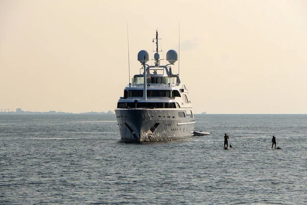 Yate de crucero blanco de lujo en Maldivas océano y tabla de servir con serfer en él — Foto de Stock