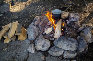 Vahşi kamp kamp ateşi bir tencerede yemek hazırlama