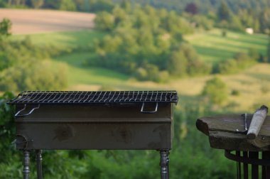Boş taşınabilir Barbekü Izgara önünde taze yeşil yaz manzara, yakın çekim