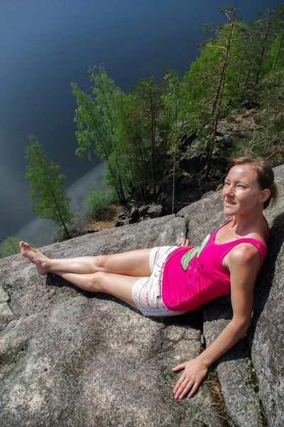 kadın bir göl Yastrebinoye, Leningrad region, Rusya Federasyonu bölgesinde Priozersky yukarıda rahatlatıcı Cliff üzerinde döşeme