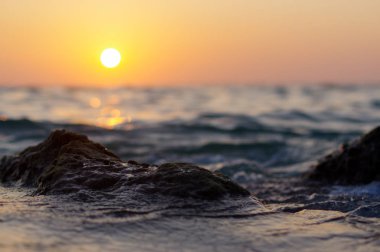 dalga deniz günbatımı zaman su üzerinde kırmızı ve turuncu güneş yansıması ile kapatın. doğa soyut arka plan bulanık. Phuket Island, Tayland