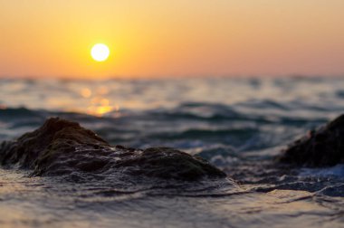 dalga deniz ve rock yakın kırmızı turuncu güneş yansıması su ile günbatımı zamanı at. doğa soyut arka plan bulanık. Phuket Island, Tayland