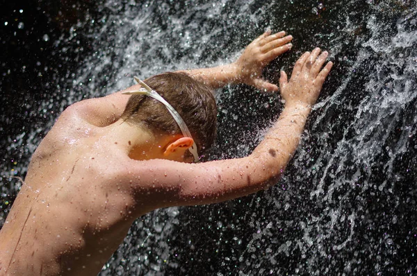 Ragazzo facendo una doccia rilassante sotto cascata. fuori — Foto Stock