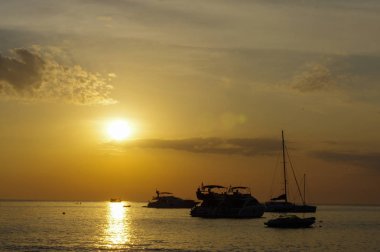 rock siluetleri ve Phuket Island, Tayland gemilerde su üzerinde şaşırtıcı tropikal turuncu günbatımı