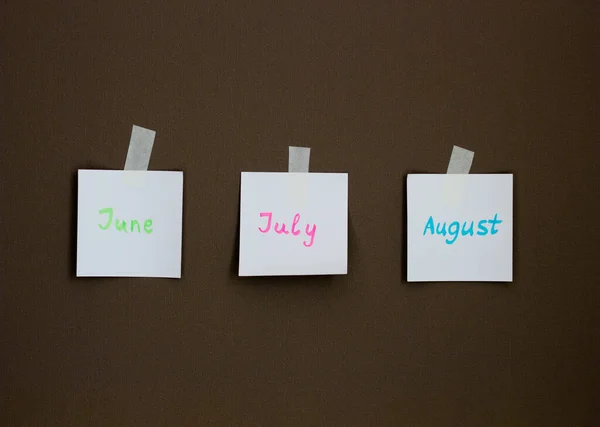 Sticky notes on the wall background. Business/education memo planning. Summer months motivation notes. June, July, August