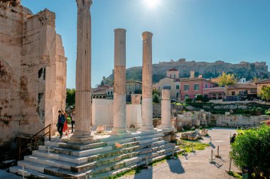 Atina / Yunanistan - Aralık 12019: Hadrian Kütüphanesi 'nin kalıntıları, 132 yılında Roma İmparatoru Hadrian tarafından oluşturuldu. Arka planda Plaka 'nın tarihi ilçesi ve Atina Akropolü yer alıyor..