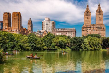 Nyc, Ny / Usa - 12 Temmuz 2014: Arka planda Yukarı Batı Manhattan silueti olan Central Park Gölü 'nde insanlar kürek çekiyor.