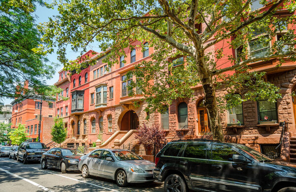 NYC, NY / USA - July 12 2014: View of 120 Street East, in Harlem, Manhattan.The brownstones dominate the picture.