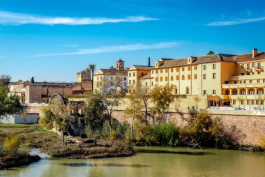 Alcazar de los Reyes Cristianos (diğer adıyla Cordoba Alcazar) ve Guadaquivir nehrinin kıyısındaki Cordoba, Endülüs, İspanya 'daki ortaçağ değirmeni. Fotoğraf Roma Köprüsü 'nden çekildi..