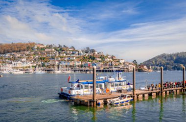 Dartmouth / UK - 21 Nisan 2014: Yolcular Kuzey Embankment terminalinden feribota binmeye hazırlar. Kingswear, Dart nehrinin doğu kıyısındaki bir köy, arka planda..