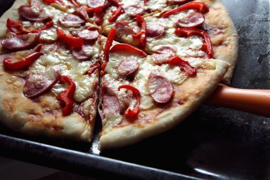 Taze pişmiş pizza, parçalar halinde kesilmiş.