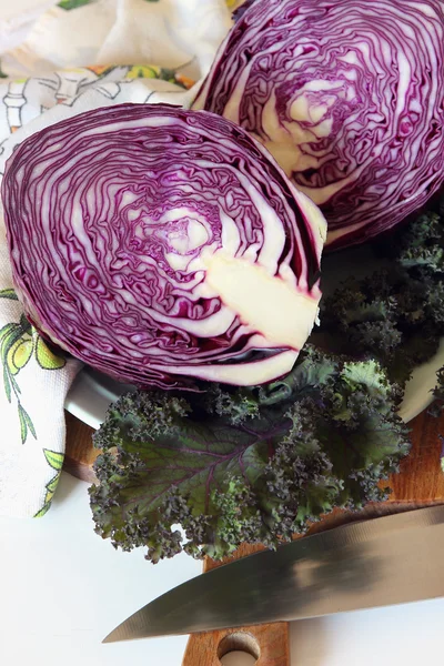 A head of purple cabbage cut in half on the board. — Stock Photo, Image