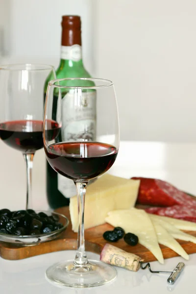Twee glazen en een fles rode wijn verzamelaar. — Stockfoto
