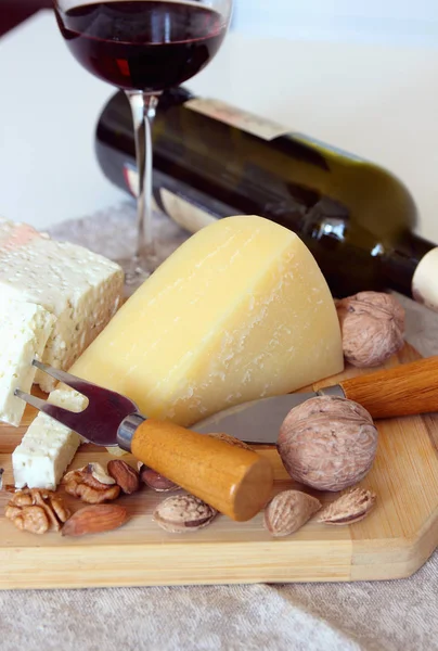 Peynir, fındık ve bir kadeh şarap. — Stok fotoğraf