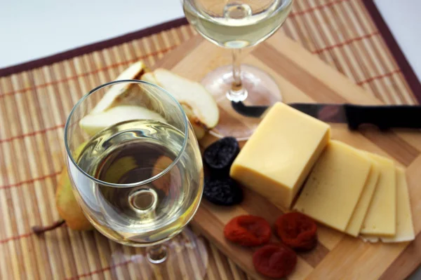 Glas med vitt vin och ost med frukt. — Stockfoto