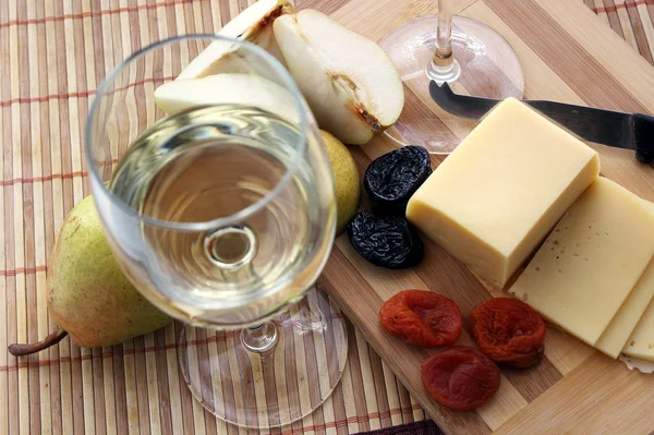 Sklenice s bílým vínem a sýrem s ovocem. — Stock fotografie