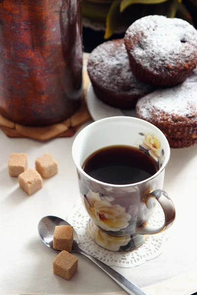 Une tasse de café et des muffins au chocolat fraîchement cuits . — Photo