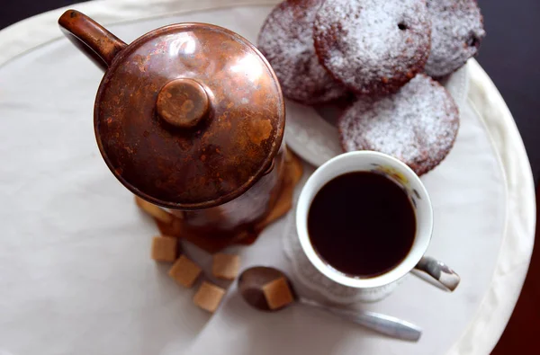 Une tasse de café, une cafetière en cuivre et des muffins au chocolat fraîchement cuits . — Photo