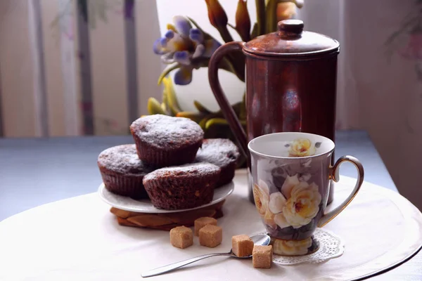 Une tasse de café et des muffins au chocolat fraîchement cuits . — Photo