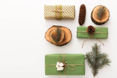 Çam kozalaklarından, brançlardan, ağaç halkalarından, beyaz masa üzerinde plastik olmayan el yapımı hediyelerden oluşan Noel kompozisyonu. Noel, Noel, Noel, kış, yeni yıl, sıfır atık kavramı. Üst görünüm, fotokopi alanı, düz alan.