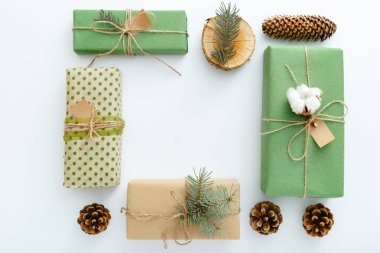 Sıfır boşa geçen Noel. Çam kozalaklarından, dallardan, mumlardan, ağaç halkalarından yapılmış çerçeveler, beyaz masada plastik olmayan el yapımı hediyeler. Üst görünüm, kapat, boşluğu kopyala, arkaplan, düzleştir.