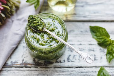 Şarap sosu eski kaşık içinde, cam kavanozda pesto sosu, malzemeli fettuccine, kırsal beyaz ahşap masa. Makarna, spagetti, bruschetta ve pizza yapmak için geleneksel İtalyan pesto tarifi..