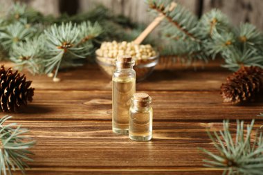 Cam şişelerdeki doğal çam yağı ilaç, aromaterapi, spa ve sağlık için kavanozda. Ahşap arka planda fotokopi alanı olan Aroma Woody. Doğal banyo ürünleri, alternatif tıp malzemeleri.