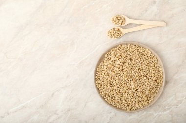 Tabakta çam fıstığı ve mermer bir masada yemek için tahta kaşıklar. Keto diyeti, sağlıklı vejetaryen yemeği kavramı. Metin için üst görünüm veya düz görünüm kopyalama alanı