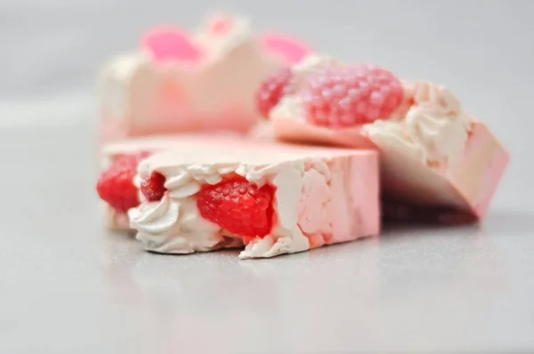 Handmade pink soap.Cold Processed Handcrafted Soap.Home made soap look like cake, ice cream with berries,glitter on gray background with sparkles.Natural homemade cosmetics and handmade soaps concept