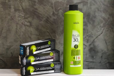 L 'oreal Profesnel Paris' ten Saç Renkleri Inoa için kozmetik seti. Inoa Loreal oksidan zenginliği ve profesyonel saç boyası gri arka planda sarı saç teli olan kuaförler için kutularda..