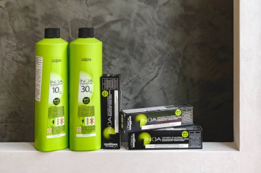 L 'oreal Profesnel Paris' ten Saç Renkleri Inoa için kozmetik seti. Inoa Loreal oksidan zenginliği ve profesyonel saç boyası gri arka planda sarı saç teli olan kuaförler için kutularda..