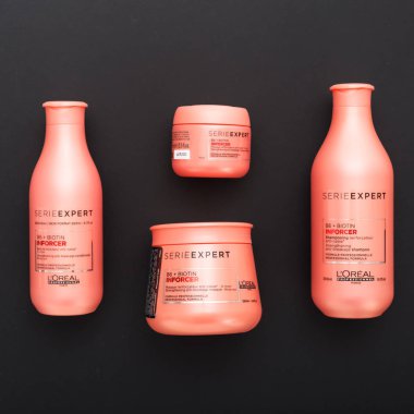 L 'oreal Profesnel Paris Serie Expert Inforcer saç profesyonel ürünleri. Saç için Loreal şampuan kremi kremi. Siyah arka planda yatıyordu. Pembe saç kozmetik şişeleri.