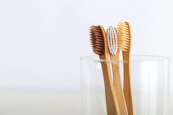 Escovas de dentes de bambu naturais em vidro sobre fundo branco. Conjunto de escovas de dentes de bambu naturais biodegradáveis. Eco amigável, zero desperdício, cuidados dentários, conceito livre de plástico. Fechar com espaço de cópia para te — Fotografia de Stock