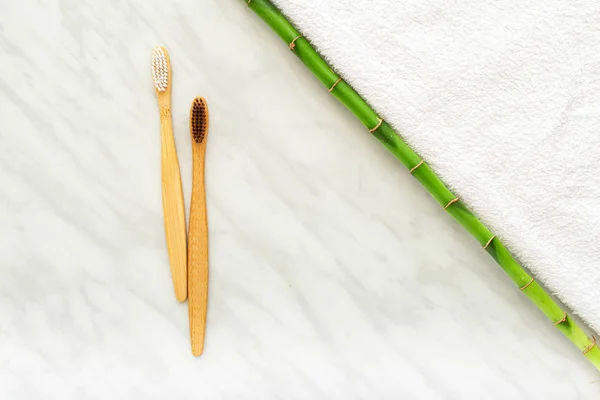 Bamboo toothbrushes, bamboo plant on white towel, marble background. Flat lay. Natural bath products.Biodegradable natural bamboo toothbrush.Eco friendly, Zero waste, Dental care Plastic free concept — Stock Photo, Image