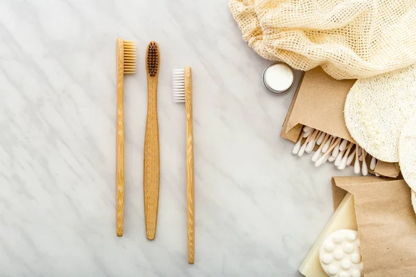 Zero waste natural bath product.Bamboo toothbrushes, soap Cotton Swabs Wooden Sticks,loofah washcloths on white marble background.Flat lay copy space.Eco friendly, Zero waste, Plastic free Dental care — Stock Photo, Image