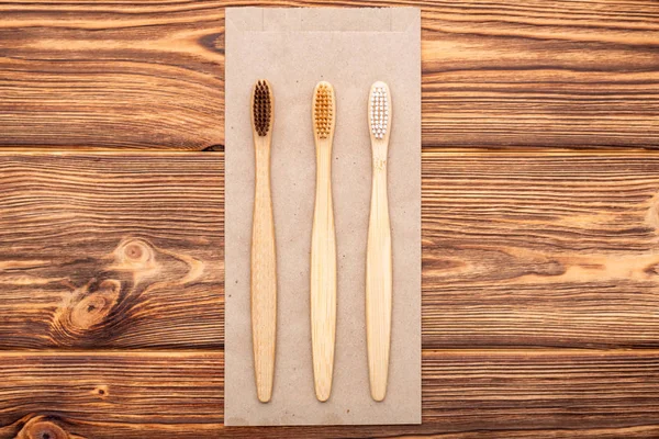 Bamboo toothbrushes on wooden background. Flat lay with copy space. Natural bath products. Biodegradable natural bamboo toothbrush. Eco friendly, Zero waste, Dental care Plastic free concept — Stock Photo, Image